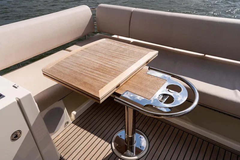 Slide: The Image of Luxurious Prestige F4.9 yacht interior with wooden table and cushioned seating, 2025 model. - 57