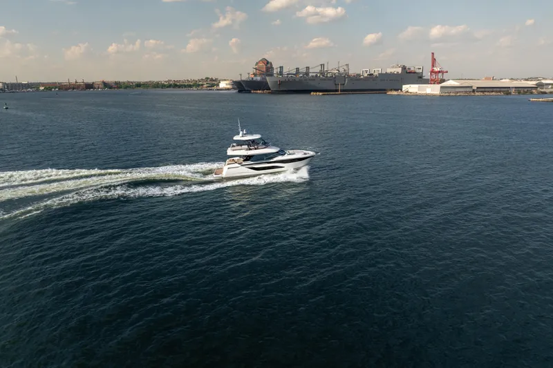 Slide: The Image of Prestige F4.9 yacht cruising in open water, 2025 model, with industrial backdrop. - 7