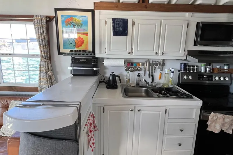 Slide: The Image of Compact kitchen in 2017 Catamaran Cruisers Aqualodge with white cabinets and appliances. - 6
