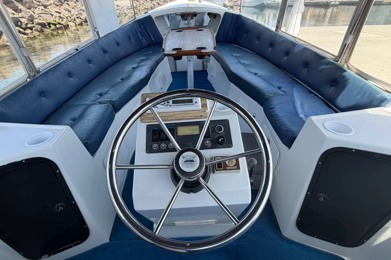 Slide: The Image of Interior of a 1996 Duffy Classic 21 boat with blue seating and steering wheel. - 20