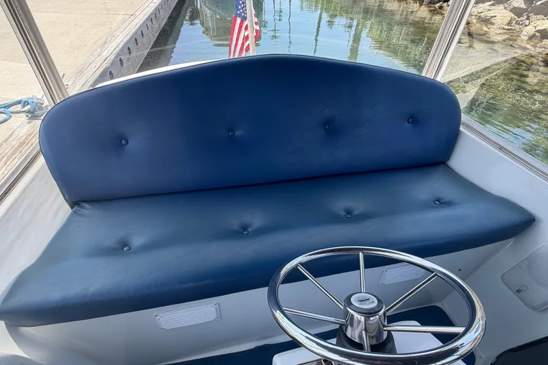 Slide: The Image of Blue cushioned seating and steering wheel on a 1996 Duffy Classic 21 boat. - 22