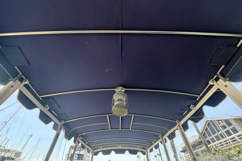 Slide: The Image of Blue canopy of a 1996 Duffy Classic 21 boat with metal frame and light fixture. - 25