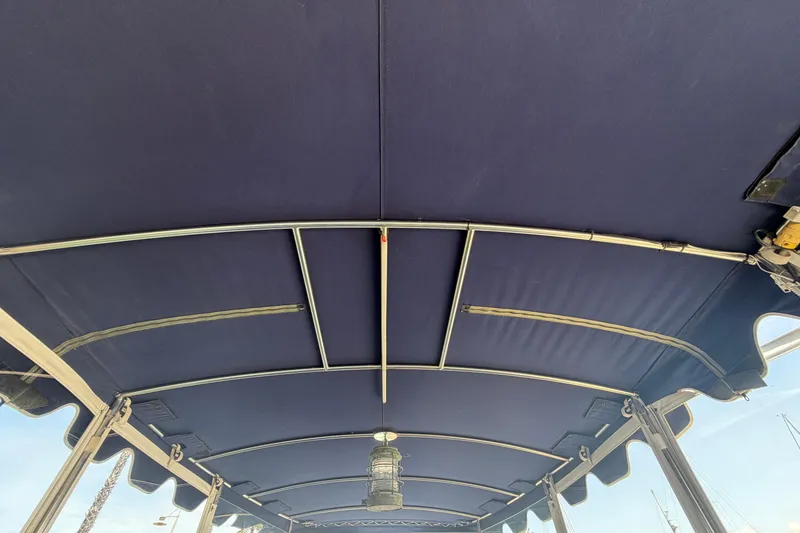 Slide: The Image of Blue canopy roof of a 1996 Duffy Classic 21 boat, featuring metal support frames. - 26