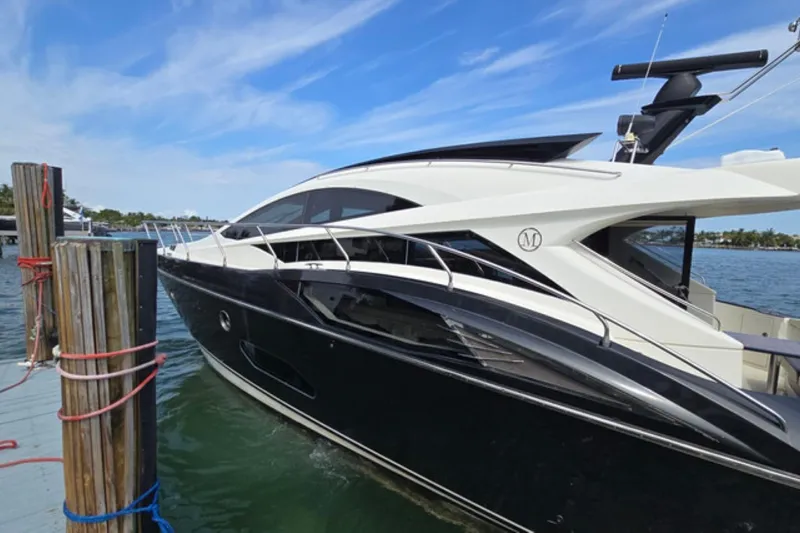 Slide: The Image of 2009 Marquis 500 Sport Coupe yacht docked by the water under a clear blue sky. - 2