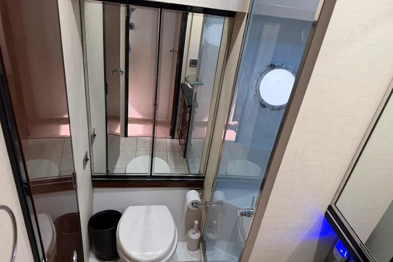 Slide: The Image of Luxurious bathroom in 2009 Marquis 500 Sport Coupe yacht with modern fixtures and porthole window. - 28