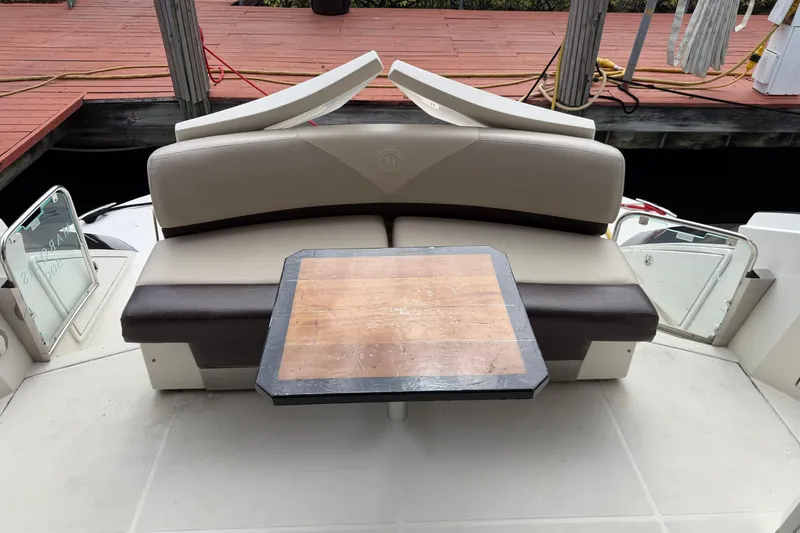 Slide: The Image of 2009 Marquis 500 Sport Coupe boat interior with seating and wooden table. - 8
