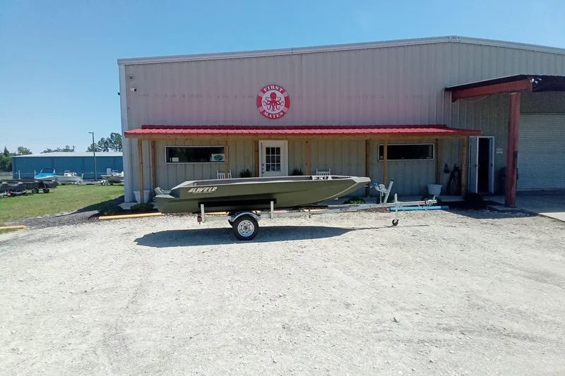 Slide: The Image of 2026 Alweld 1652 Invader boat on trailer outside a warehouse. - 1
