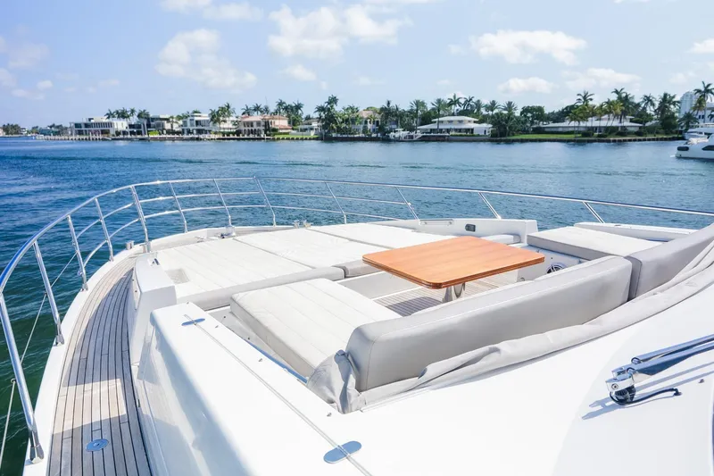 Slide: The Image of Luxurious 2017 Azimut Fly 72 yacht deck with seating and table, overlooking serene waterfront homes. - 56