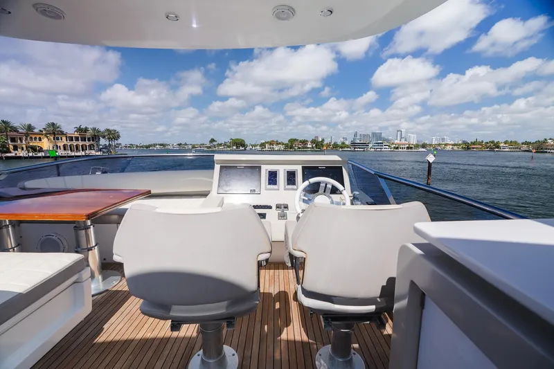 Slide: The Image of Flybridge view from 2017 Azimut Fly 72 yacht, overlooking serene waterfront and city skyline. - 77