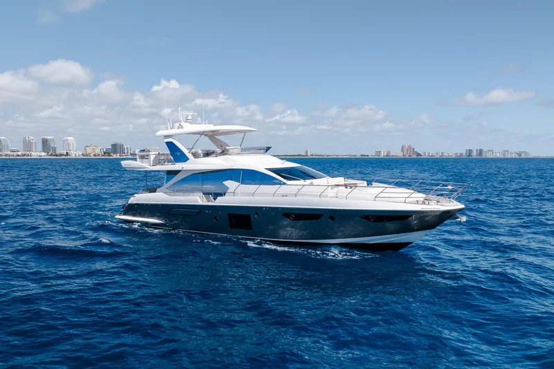 Slide: The Image of Luxurious 2017 Azimut Fly 72 yacht cruising on open blue sea with city skyline backdrop. - 9