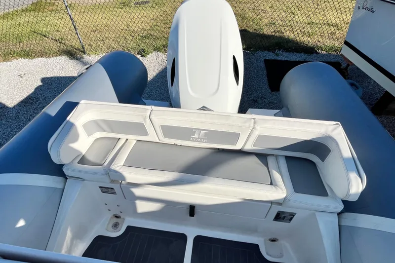 Slide: The Image of 2023 Inmar 550R-YS Yacht Series boat interior with cushioned seating and motor. - 13
