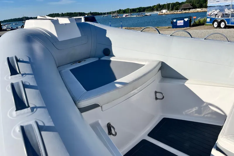 Slide: The Image of 2023 Inmar 550R-YS Yacht Series interior with seating, docked by a scenic waterfront. - 21