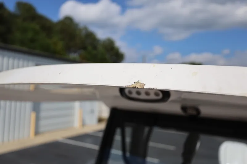 Slide: The Image of Damaged edge on 2022 Sea Hunt Ultra 239 SE boat roof under blue sky. - 21