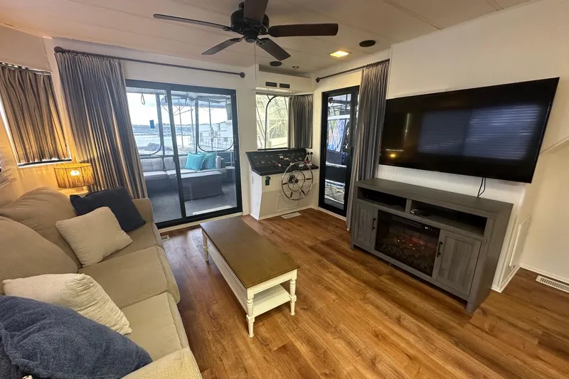 Slide: The Image of Cozy living area in a 1992 Sumerset 14x64 houseboat with modern decor and lake view. - 3