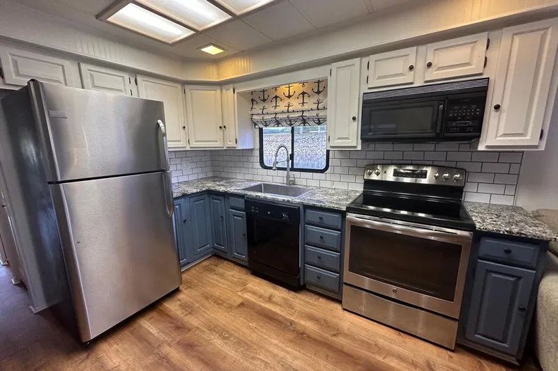 Slide: The Image of Modern kitchen in 1992 Sumerset 14x64 houseboat with stainless steel appliances and granite countertops. - 4
