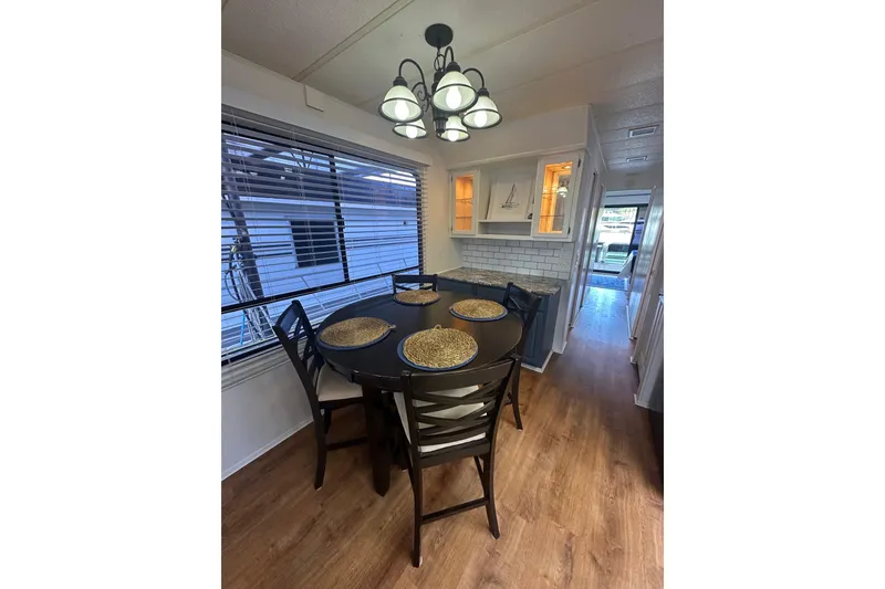 Slide: The Image of Dining area in 1992 Sumerset 14x64 houseboat with round table and modern lighting. - 5