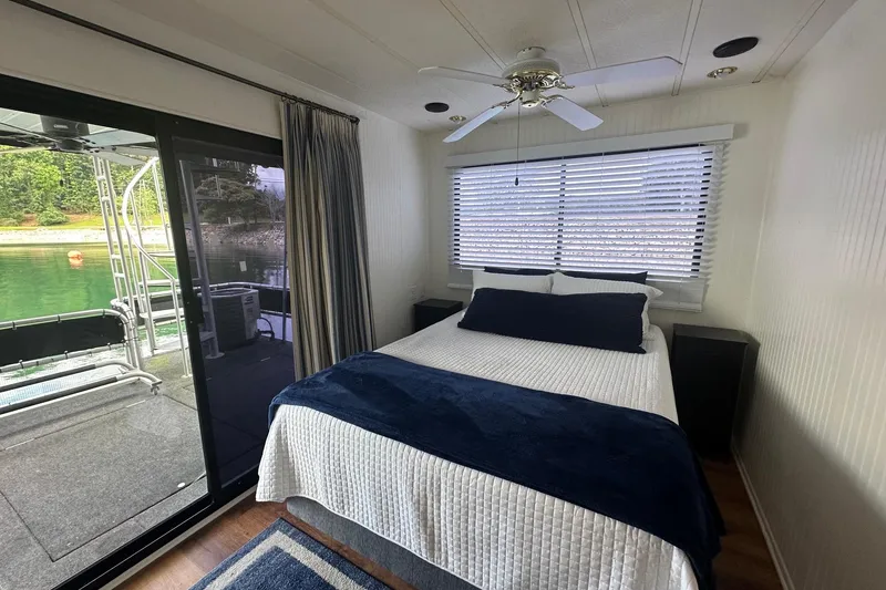Slide: The Image of Cozy bedroom in 1992 Sumerset 14x64 houseboat with lake view and modern decor. - 9