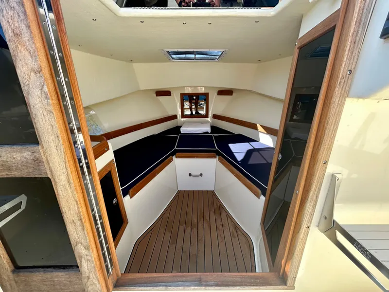 Slide: The Image of Interior of 2021 Seaway 21 Seafarer Cuddy with wood accents and blue cushions. - 10