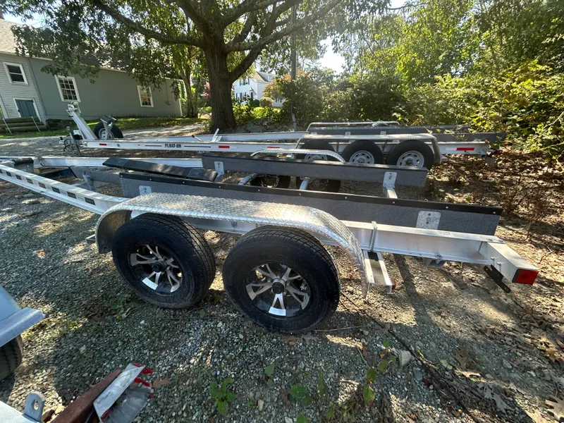 Slide: The Image of 2021 Seaway 21 Seafarer Cuddy trailer parked outdoors, dual axle, surrounded by trees. - 15
