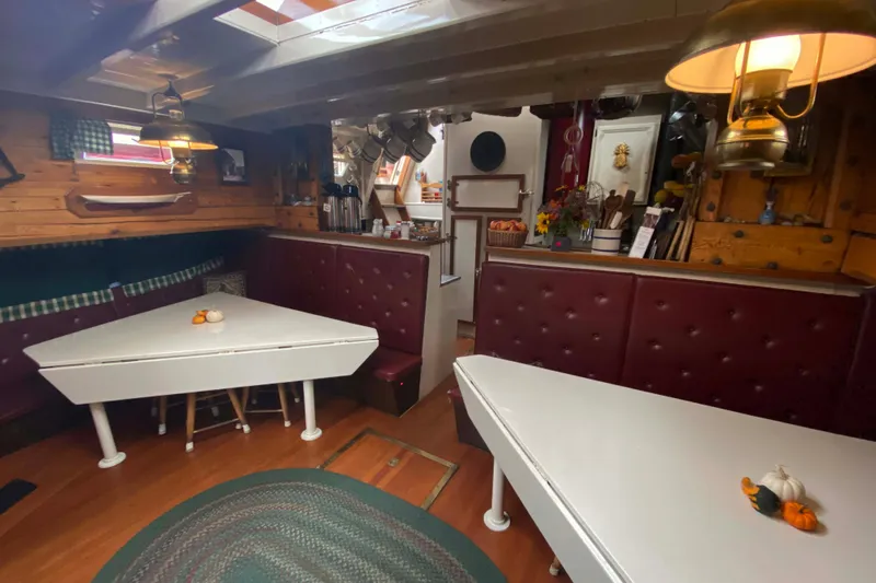 Slide: The Image of Interior of a 1962 Classic Coasting Schooner with cozy dining area and vintage decor. - 14
