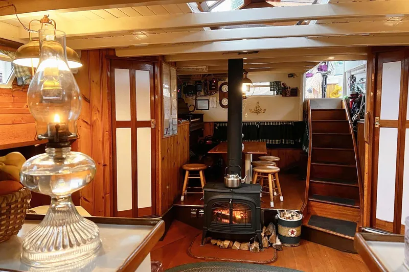 Slide: The Image of Interior of a 1962 Classic Coasting Schooner with wood stove and cozy seating area. - 15