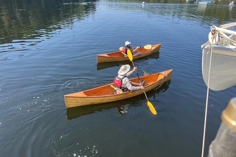 Slide: The Image of Two people kayaking near a 1962 Classic Coasting Schooner on a calm lake. - 17