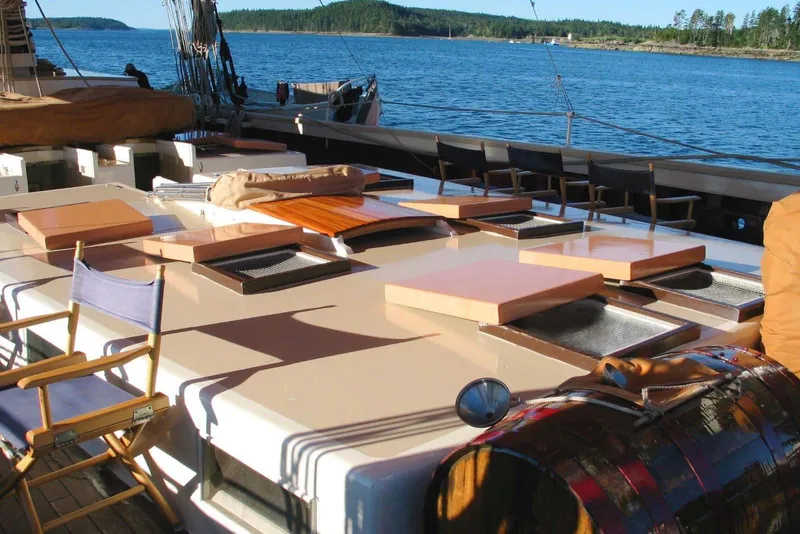 Slide: The Image of Classic 1962 Coasting Schooner deck with chairs, hatches, and scenic ocean view. - 5