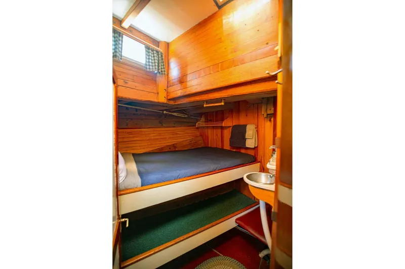 Slide: The Image of Cozy wooden cabin interior of a 1962 Classic Coasting Schooner with bunk bed and sink. - 9