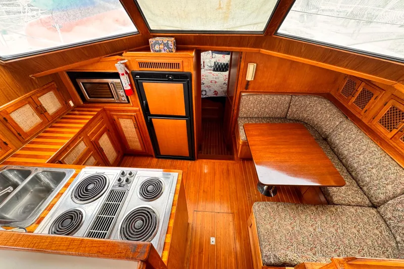 Slide: The Image of 1985 Symbol 51 yacht interior with kitchen, dining area, and wooden cabinetry. - 10