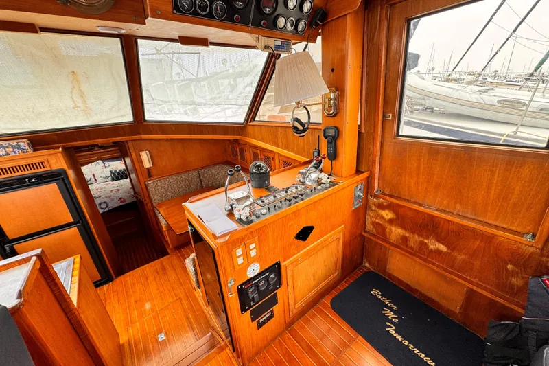 Slide: The Image of 1985 Symbol 51 yacht interior with wooden paneling and navigation controls. - 13