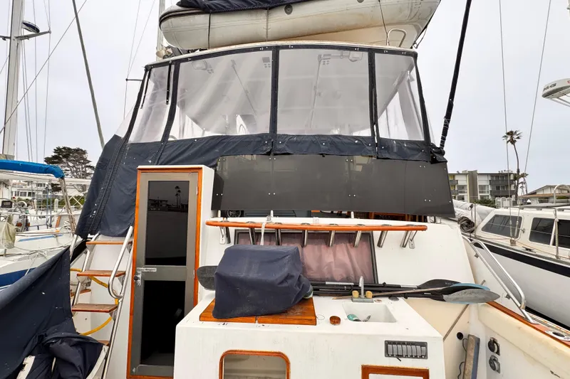 Slide: The Image of 1985 Symbol 51 yacht with covered cockpit and visible marina background. - 2