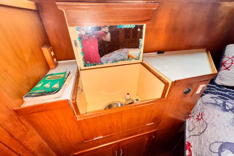 Slide: The Image of Wooden vanity with mirror and sink in a 1985 Symbol 51 boat interior. - 22