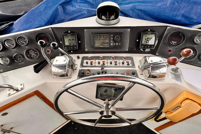 Slide: The Image of Boat control panel with steering wheel, gauges, and levers on a 1985 Symbol 51 model. - 25