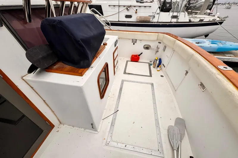 Slide: The Image of 1985 Symbol 51 boat deck with storage, paddles, and cleaning supplies at marina. - 3