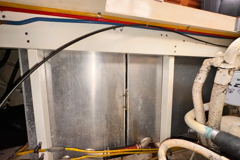 Slide: The Image of Engine room of a 1985 Symbol 51 yacht with visible pipes and wiring. - 30