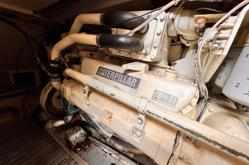Slide: The Image of Engine room featuring a 1985 Caterpillar engine with visible pipes and components. - 34