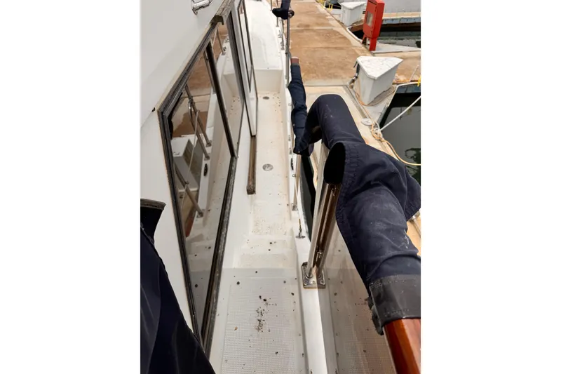 Slide: The Image of 1985 Symbol 51 yacht deck with covered railings and dock view. - 37