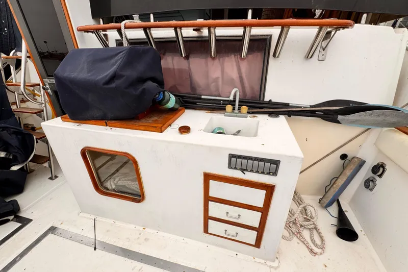 Slide: The Image of Outdoor boat sink area with storage, paddles, and covered equipment on a 1985 Symbol 51 model. - 4