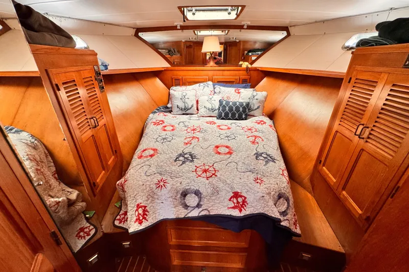 Slide: The Image of Cozy 1985 Symbol 51 yacht cabin with nautical-themed bedding and wooden cabinetry. - 8