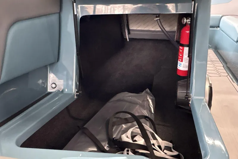 Slide: The Image of Storage compartment of 2026 MasterCraft NXT22 boat with fire extinguisher and bag. - 14