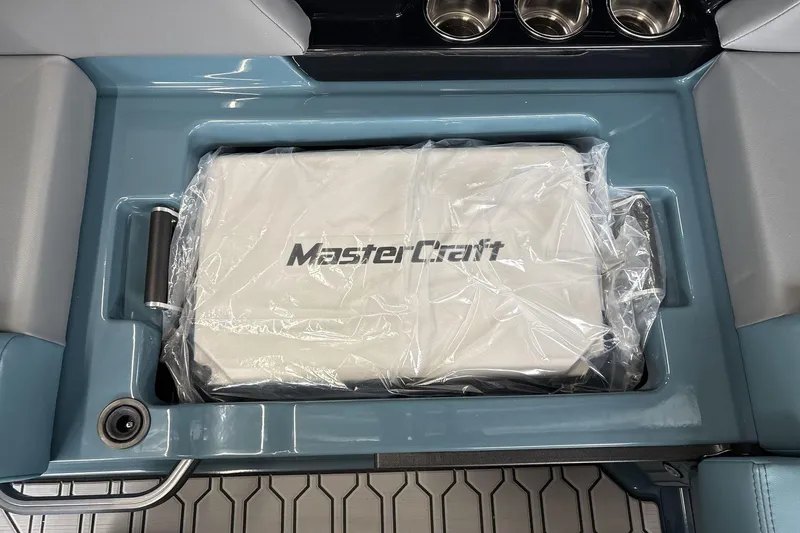 Slide: The Image of 2026 MasterCraft NXT22 boat interior with branded storage compartment and cup holders. - 18