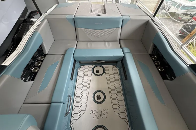 Slide: The Image of 2026 MasterCraft NXT22 boat interior with gray and blue seating, hexagonal floor design. - 6