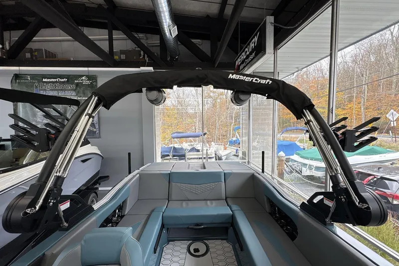 Slide: The Image of 2026 MasterCraft NXT22 boat interior with wakeboard tower in showroom. - 8