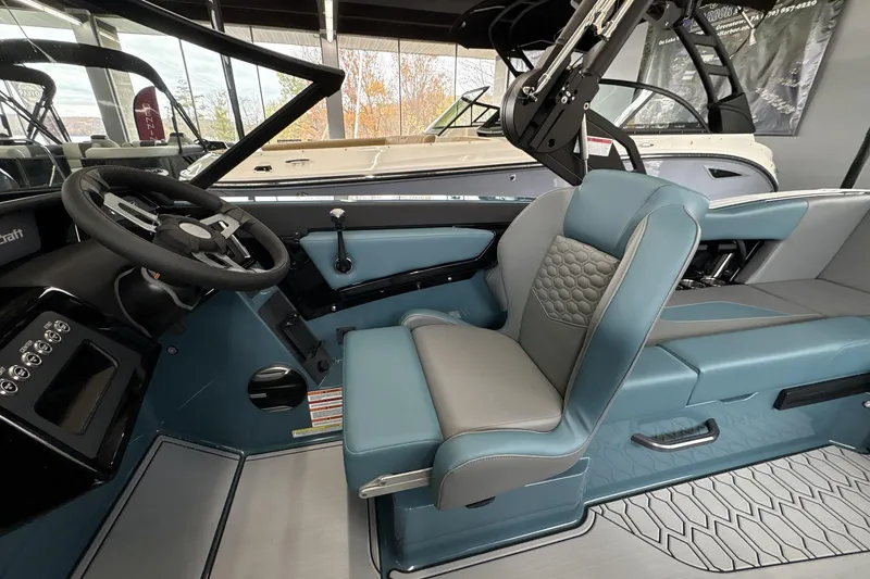 Slide: The Image of 2026 MasterCraft NXT22 boat interior with modern steering and blue seating. - 9