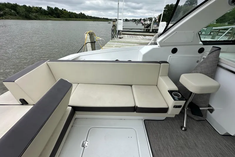 Slide: The Image of 2018 Monterey 360 Sport Coupe interior with beige seating, docked by a serene river. - 11
