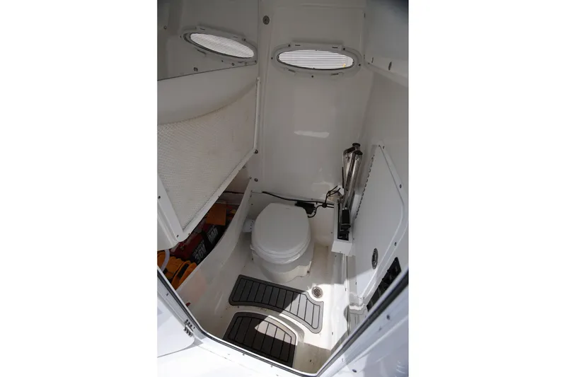 Slide: The Image of 2024 Sea Hunt Ultra 275 SE boat interior bathroom with toilet and storage. - 13