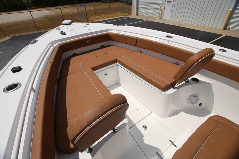 Slide: The Image of 2024 Sea Hunt Ultra 275 SE boat with brown cushioned seating and white deck. - 14