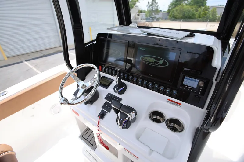 Slide: The Image of 2024 Sea Hunt Ultra 275 SE boat dashboard with steering wheel and electronic controls. - 18