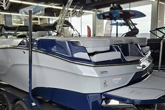 Slide: The Image of 2026 MasterCraft XT24 boat in showroom, featuring sleek design and modern amenities. - 2