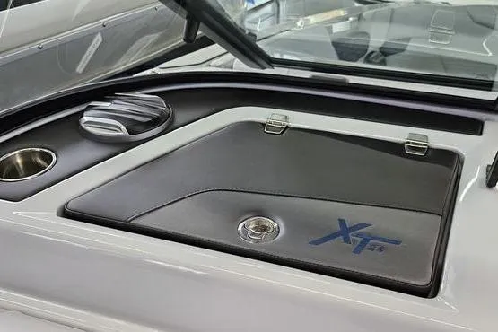 Slide: The Image of 2026 MasterCraft XT24 boat interior detail with storage compartment and cup holder. - 24